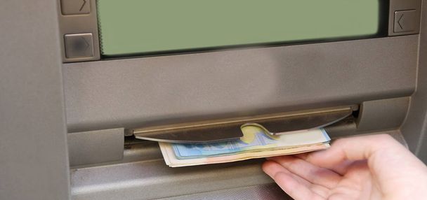 main prend de l'argent à la machine ATM
 - Photo, image