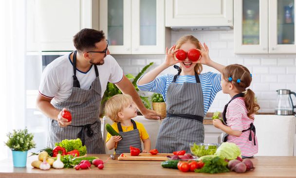 glückliche Familie mit Kindern bereitet Gemüsesalat bei hom zu - Foto, Bild
