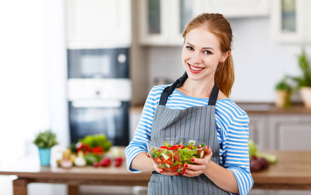 happy woman preparing vegetable salad in the kitche - Photo, Image