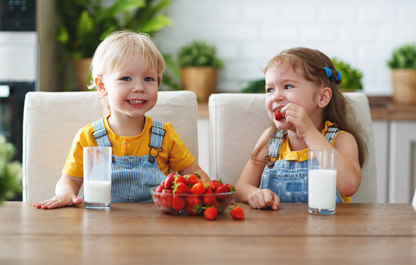 Heureux enfants fille et garçon frère et soeur manger des fraises avec mil
 - Photo, image