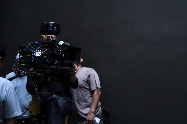 a cameraman with his team working in studio for shooting a movie - Photo, Image