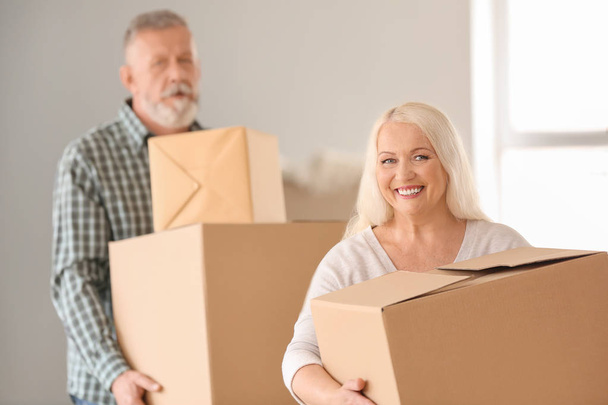Mature couple with moving boxes at new home - Photo, Image