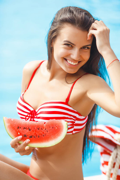 Very beautiful woman with watermelon in the pool - Φωτογραφία, εικόνα