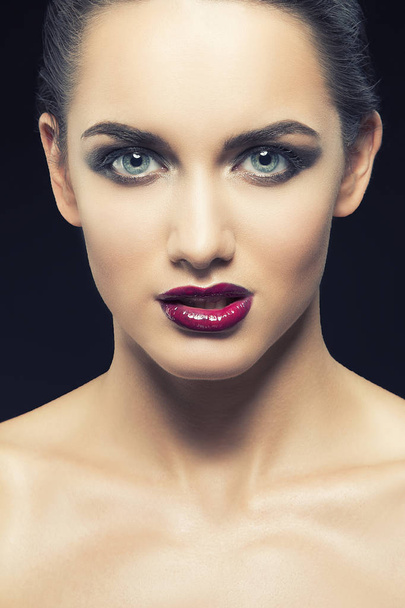 young woman with purple lips posing on black background - Photo, Image