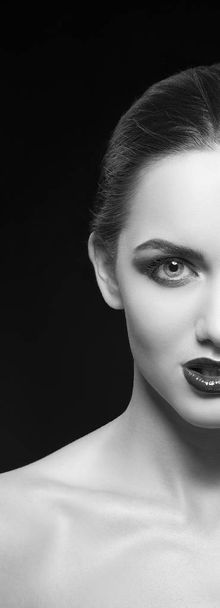 Halbgesicht einer jungen Frau mit dunklen Lippen auf schwarzem Hintergrund - Foto, Bild