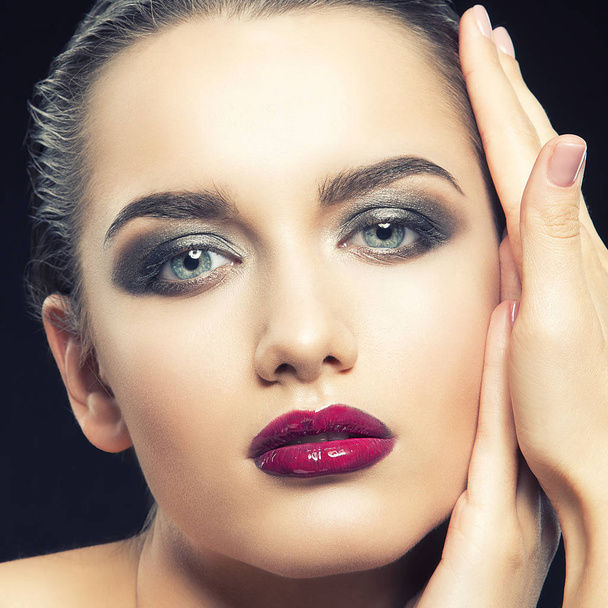 young woman with purple lips posing on black background - Photo, Image