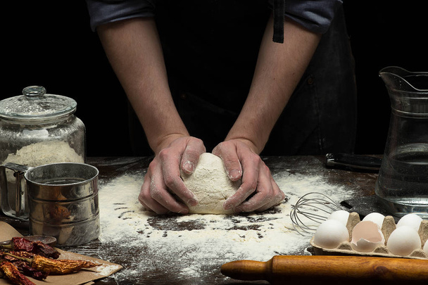 Hands are mixing a dough on wooden table - Φωτογραφία, εικόνα