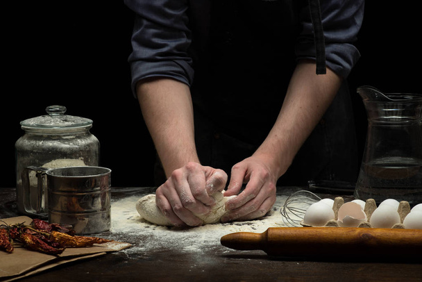 Hands are mixing a dough on wooden table - Φωτογραφία, εικόνα