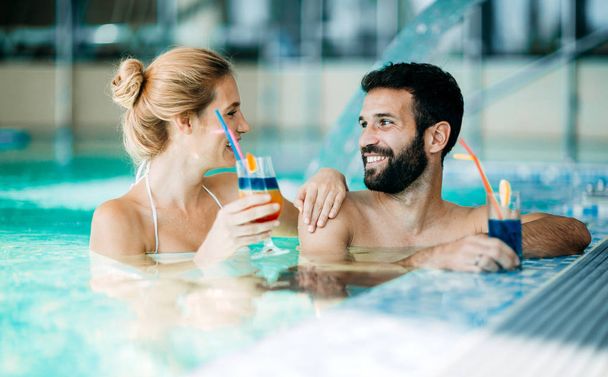 Happy attractive couple relaxing in spa swimming pool - Foto, Imagen