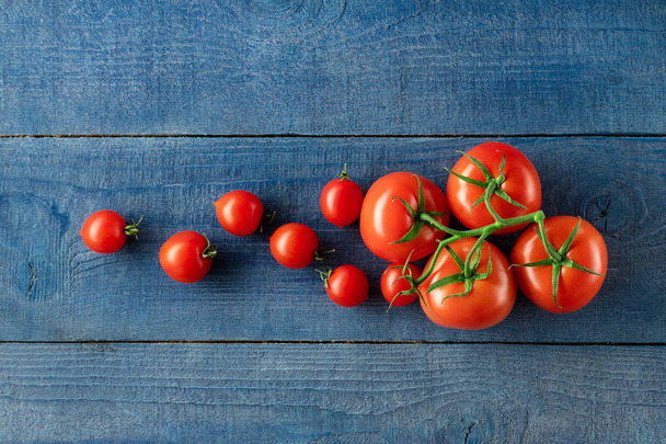 Set of ripe tomatoes on blue wooden background - Fotografie, Obrázek