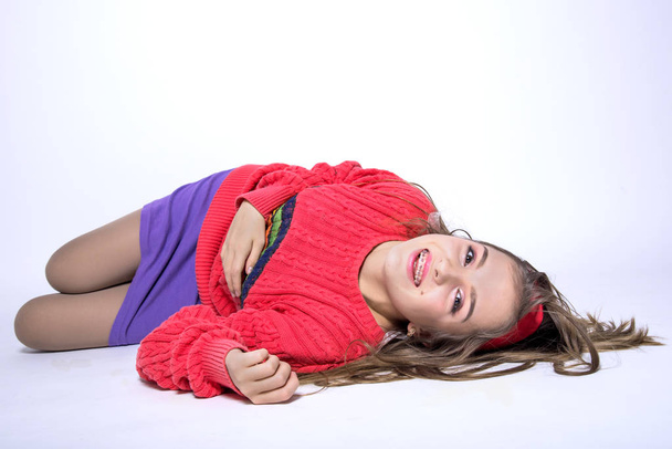 Krásná mladá dospívající dívka s držáky na zuby ležící v bílém - Fotografie, Obrázek