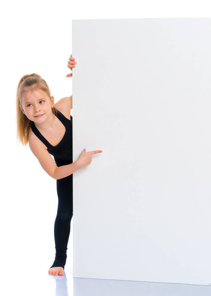Little girl points a finger at a white banner. - Foto, Imagen