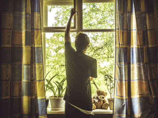 man staande in de slaapkamer opening Window Leaf - Foto, afbeelding