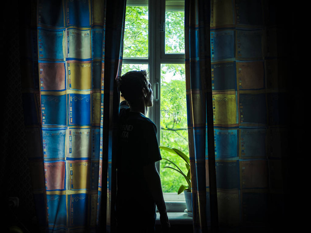 sozinho homem silhueta olhando para a janela fechada com cortinas no quarto
 - Foto, Imagem