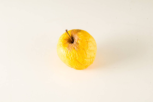Old apple that is beginning to rot isolated - Photo, Image