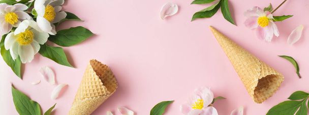Spring or summer mood concept. Flat-lay of waffle sweet cone with berryy over pastel light pink background, top view. - Foto, afbeelding