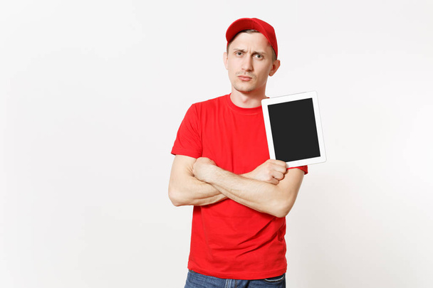 Liefermann in roter Uniform isoliert auf weißem Hintergrund. Mann mit Mütze, T-Shirt, Jeans, der als Kurier oder Händler arbeitet, Tablet-PC mit leerem Bildschirm in der Hand. Kopierfläche für Werbung - Foto, Bild