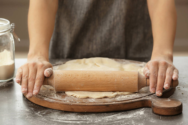Woman rolling dough on kitchen table, closeup - Photo, Image