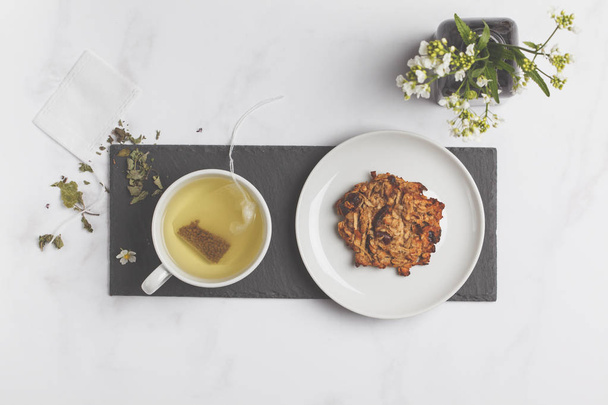 Green (herbal, white) tea with cookies on white background. Flat lay food, breakfast lifeslyle concept - Fotó, kép