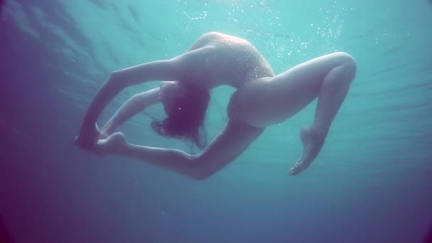 Krásná dívka pod vodou / Krásná žena v jiskřivých plavkách pózující pod vodou - video ve zpomaleném filmu - Záběry, video