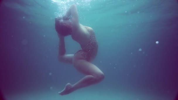 Krásná dívka pod vodou / Krásná žena v jiskřivých plavkách pózující pod vodou - video ve zpomaleném filmu - Záběry, video