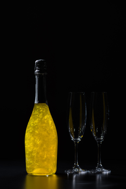 close up view of bottle of champagne and empty glasses on black background - Photo, Image