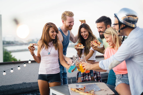 Group of happy young friends having party on rooftop - Foto, Bild