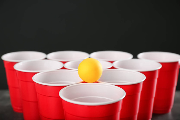 Чашки і м'яч для пивного понг на столі, крупним планом
 - Фото, зображення