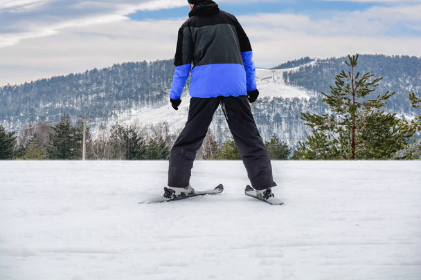 Skiing man on ski in jacket ready for skiing with big ski track in the background - Valokuva, kuva