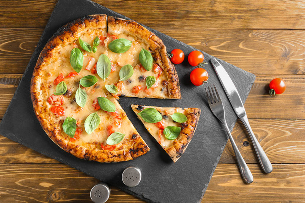 Ahşap arka plan üzerinde lezzetli pizza Margherita ile kompozisyon - Fotoğraf, Görsel
