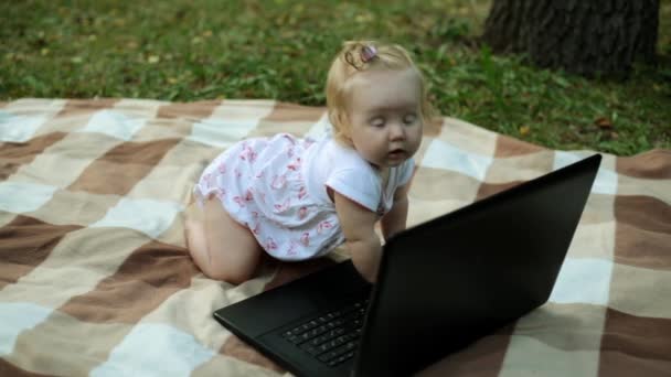 Little child with laptop in the park. - Materiał filmowy, wideo