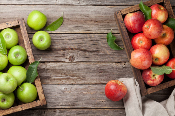 Dojrzałe jabłka zielone i czerwone w drewnianych skrzynkach. Widok z góry z miejsca na tekst - Zdjęcie, obraz
