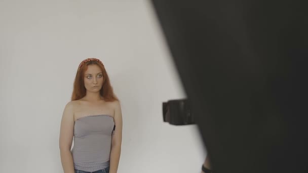 Bardzo piękna dziewczyna pozuje przed kamerą w studiu fotograficznym - Materiał filmowy, wideo