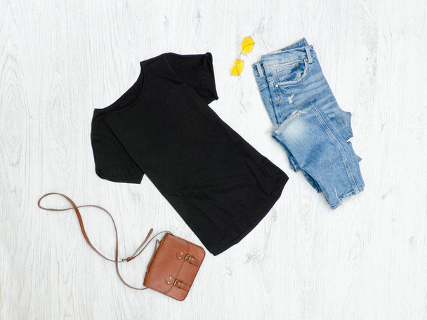 Camiseta negra, jeans rasgados, bolso y gafas de sol. Concepto de moda
 - Foto, imagen