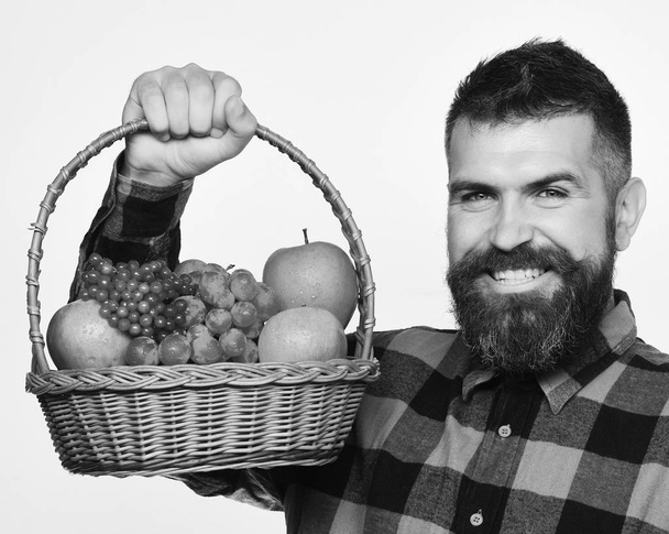Αθλητισμός και κατάρτιση μενού. Άνθρωπος με χαμόγελο κατέχει καλάθι με φρούτα σε λευκό φόντο. - Φωτογραφία, εικόνα