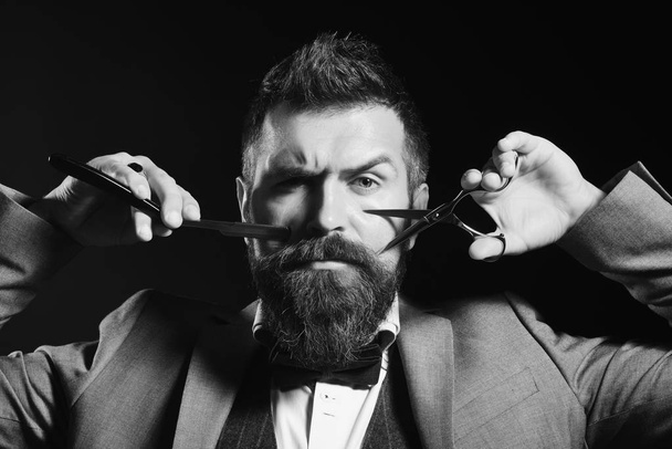 Barber shop. Hair style. Macho in formal suit cuts and shaves beard and moustache - 写真・画像