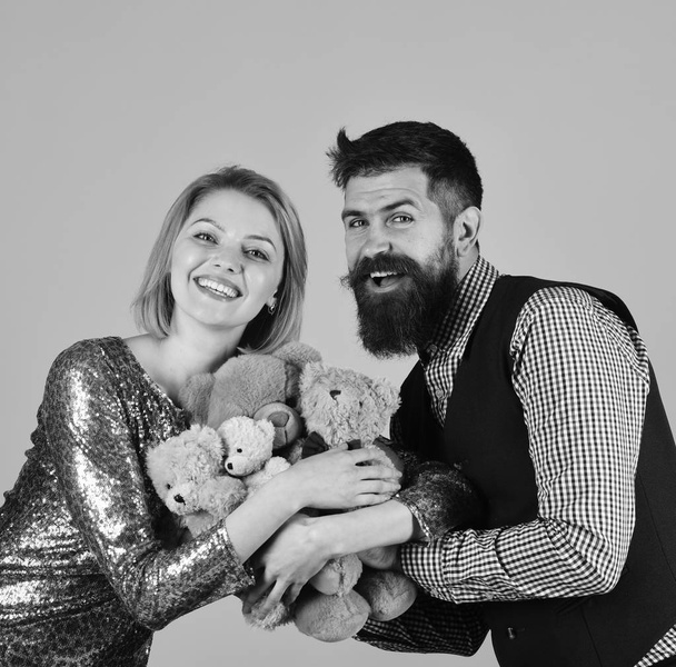 Couple in love holds heap of teddy bears on pink. Charity and love concept. - Fotografie, Obrázek