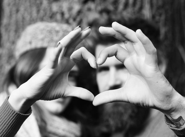 Szerelmes pár mutatja a szív jel ujjaival. Szerelmesek. - Fotó, kép