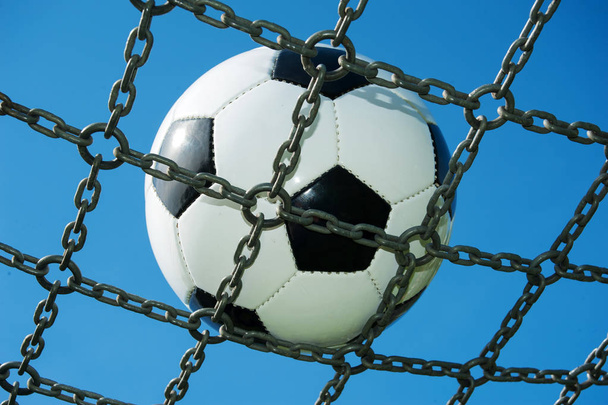 soccer ball in chain net white and black football, blue sky - Photo, Image