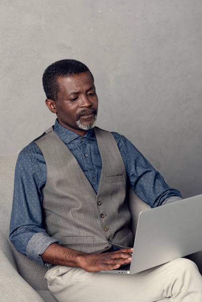 серьезный взрослый африканский американский бизнесмен, использующий ноутбук на работе
 - Фото, изображение