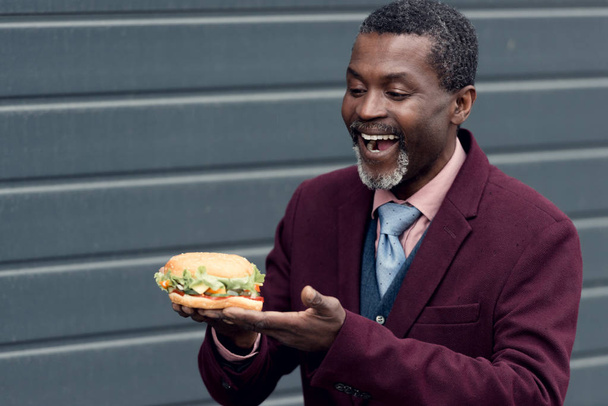 nadšený americký muž dívá na chutný hamburger - Fotografie, Obrázek