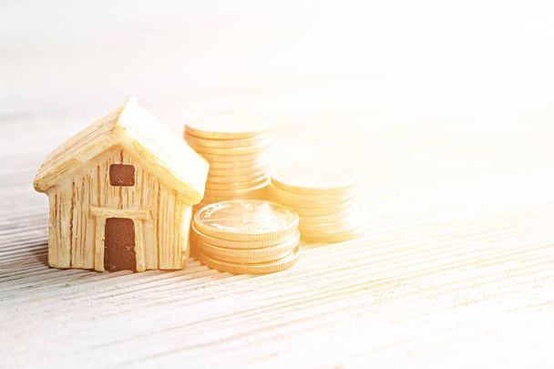 Wirtschaft, Finanzen, Sparen, Immobilien- oder Hypothekenkreditkonzept: Hausmodell und Münzen auf Bürotisch mit Kopierraum - Foto, Bild