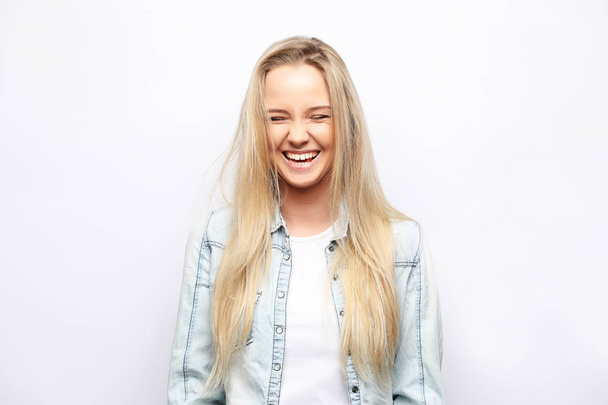 Portrait of young blonde positive female with cheerful expression, dressed in casual clothes, over white background. Beautiful woman indoor. - Foto, Imagem