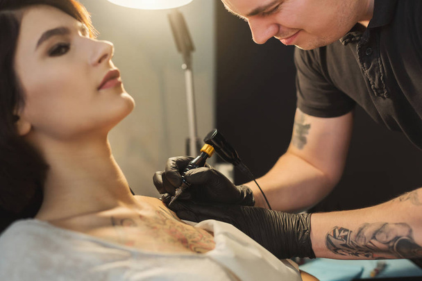 Tattoo artist working with needle on clients body - Photo, Image