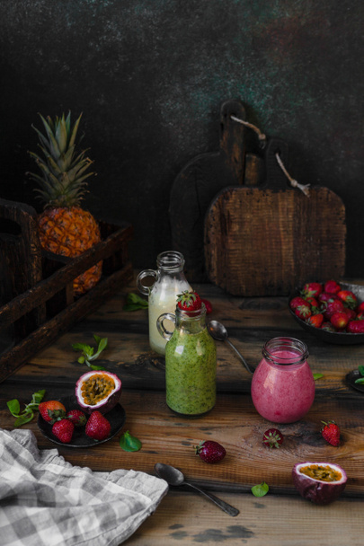 Fresh healthy smoothies on rustic table with exotic fruits - Fotoğraf, Görsel