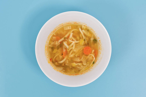 Sopa de fideos con verduras sobre un fondo blanco
 - Foto, imagen