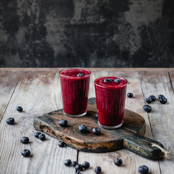 Fresh healthy berry smoothie in glasses on rustic table - Фото, зображення