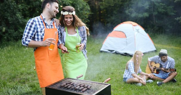 Cheerful friends spending time in nature and having barbecue - Photo, image