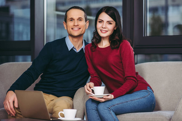 portrait of mid adult couple drinking coffee together and looking at the camera - Foto, Bild