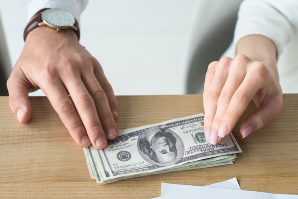 cropped shot of business partners holding stack of cash on table - Photo, Image